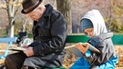 Ein Mann und ein Junge lesen auf einer Bank | Bild: colourbox.com