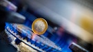 Eine 1-Euro-Münze inmitten einer blauen Gasflamme eines Gasherdes. | Bild: picture alliance / Kirchner-Media | Christopher Neundorf