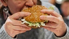 Eine Frau beißt in einen Hamburger | Bild: BR