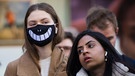 Frau mit lächelndem Mund-Nase-Schutz in London. | Bild: © picture alliance/ZUMA Press