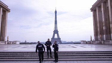 17.03.2020, Frankreich, Paris: Französische Polizisten stehen auf der leeren Trocadero-Terrasse vor dem Eiffelturm. | Bild: dpa-Bildfunk/Andreina Flores