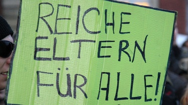 Archiv: Ein Student hält ein Schild mit der Aufschrift "Reiche Eltern für alle!" in der Hand.  | Bild: picture-alliance/dpa