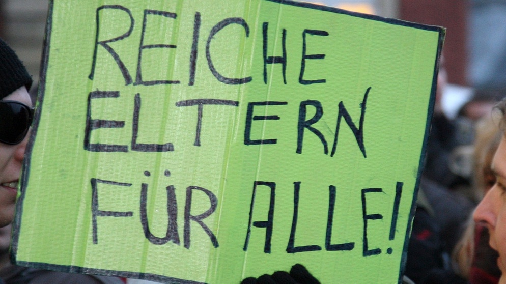 Archiv: Ein Student hält ein Schild mit der Aufschrift "Reiche Eltern für alle!" in der Hand.  | Bild: picture-alliance/dpa