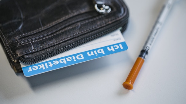 Ein Geldbeutel mit einem Diabetikerausweis und eine Einweg-Spritze. | Bild: BR/Johanna Schlüter