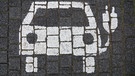 Symbol für ein E-Auto auf dem Boden eines Parkplatzes | Bild: picture-alliance/dpa