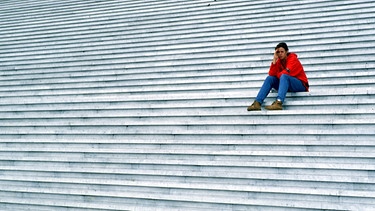 Symbolbild für Einsamkeit: Frau sitzt alleine auf einer großen Treppe | Bild: picture-alliance / Eibner-Pressefoto