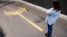Pfeile auf dem Boden zeigen nach links und nach rechts. Eine Frau überlegt, in welche Richtung sie abbiegen soll. | Bild: colourbox.com