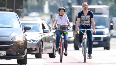 Ein Mann und eine Frau fahren am 24.05.2018 in München mit ihren Fahrraedern durch die Stadt (gestellte Szene) | Bild: picture alliance/dpa Themendienst/Tobias Hase
