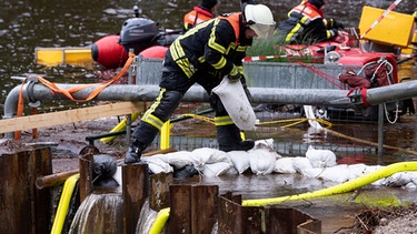 Straßlach: Feuerwehrmänner versuchen, am Deininger Weiher eine Spundwand zu öffnen, um Wasser aus dem Weiher laufen zu lassen. | Bild: dpa-Bildfunk / Sven Hoppe