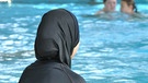 Eine Frau im Burkini in einem Hallenbad | Bild: picture-alliance/dpa