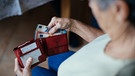 Symbolbild: Eine alte Frau hält einen Geldbeutel in ihren Händen | Bild: BR