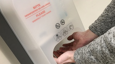 Hände unter einem Desinfektionsmittelspender | Bild: pa/dpa/Sven Simon