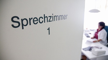 An einer Tür einer Hausarztpraxis ist der Schriftzug «Sprechzimmer 1» zu lesen. | Bild: dpa-Bildfunk/Benjamin Ulmer