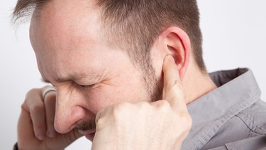 Ein Mann hält sich beide Ohren zu | Bild: picture-alliance/dpa