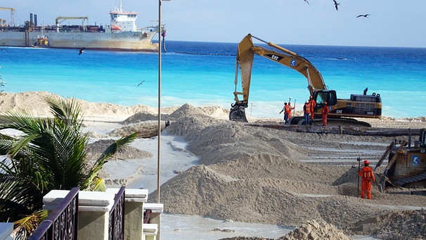 Sand wird aufgeschüttet, um Land zu vergrößern.  | Bild: dpa-Bildfunk