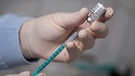 Ein Arzt zieht in einer Hausarztpraxis eine Spritze mit dem Impfstoff von Pfizer/Biontech auf. | Bild: picture-alliance/dpa