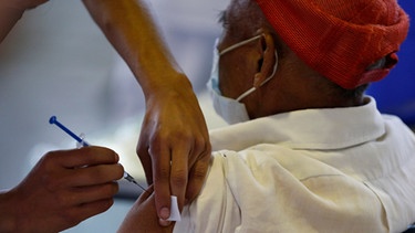 Impfungen weltweit - Symbolbild: Mexiko-Stadt: Ein medizinischer Mitarbeiter impft einen Mann
| Bild: Rebecca Blackwell/AP/dpa 