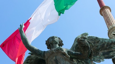 Italien: Bronzeskulptur und Flagge Italiens am Vittoriano in Rom. | Bild: picture-alliance/dpa