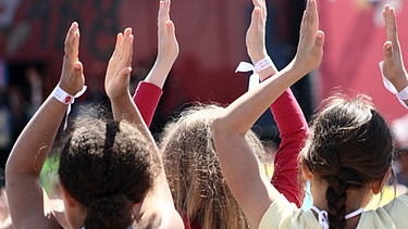 Rückenansicht von Mädchen, die zu Musik in die Hände klatschen  | Bild: colourbox.com