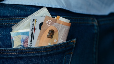 Geld und eine Gesundheitskarte in einer Hosentasche. | Bild: BR/Julia Müller