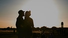 Ein Pärchen küsst sich bei Abendstimmung | Bild: dpa-Bildfunk/Annette Riedl