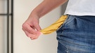 Eine Hand hält die leere, herausgezogene Hosentasche. | Bild: colourbox.com