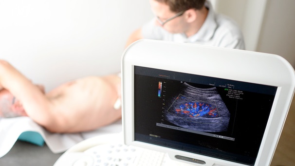 Ein Arzt untersucht die Nieren eines Patienten mittels Ultraschall. | Bild: picture-alliance/dpa