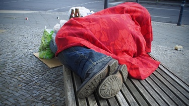 Symbolbild: Obdachloser auf einer Bank | Bild: picture-alliance/dpa