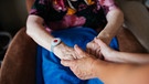 Symbolbild: Pflege zuhause: Eine junge Frau hält die Hände einer alten Frau. | Bild: BR/Julia Müller