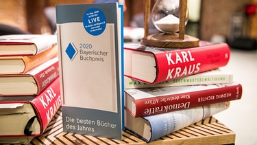 Ein Bücherstapel und eine Sanduhr | Bild: Yves Krier // Börsenverein Bayern