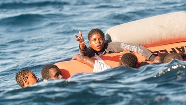 Such- und Rettungsmission im Mittelmeer vor der libyschen Küste am 27. Januar 2018. Migranten halten sich verzweifelt an Bojen im Mittelmeer fest. | Bild: picture-alliance/dpa