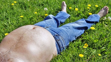 Mann mit dickem Bauch liegt auf einer Wiese | Bild: picture-alliance/ dpa | Lehtikuva Marja Airio