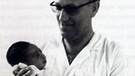 Dr. Walter Grein mit Neugeborenem in Togo | Bild: Dr. Walter Grein