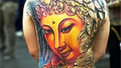 Buddha-Kopf-Tattoo auf dem Rücken eines jungen Mannes, Tattoo-Convention Frankfurt (2013) | Bild: picture-alliance/dpa