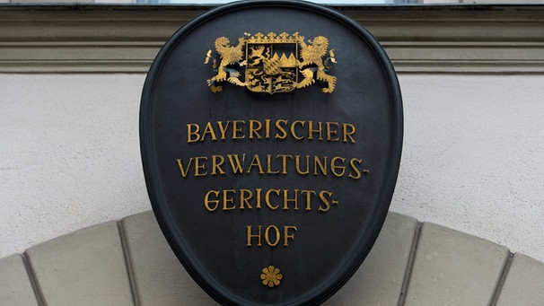 Das Türschild des Bayerischen Verwaltungsgerichtshofs hängt in München (Oberbayern) über dem Haupteingang des Gebäudes.  | Bild: picture-alliance/dpa/Peter Kneffel