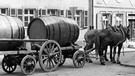 Bamberg: Während sich der Kutscher vor seiner letzten Fahrt noch stärkt, stehen die Fasswagen und Pferde kaum bemerkt auf der Straße. Aufnahme von 1961. | Bild: picture-alliance/dpa
