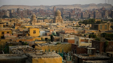 Archivbild: This Oct. 10, 2014, photo shows a general view of cemeteries located in the City of the Dead, a slum where half a million people live among tombs, in Cairo. The reality of relying on finite land resources to cope with the endless stream of the dying has brought about creative solutions.  | Bild: picture alliance / AP Photo | Hassan Ammar