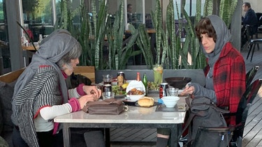 Zwei Frauen sitzen mit Kopftuch in einem Restaurant in Teheran | Bild: picture alliance/Farshid Motahari/dpa
