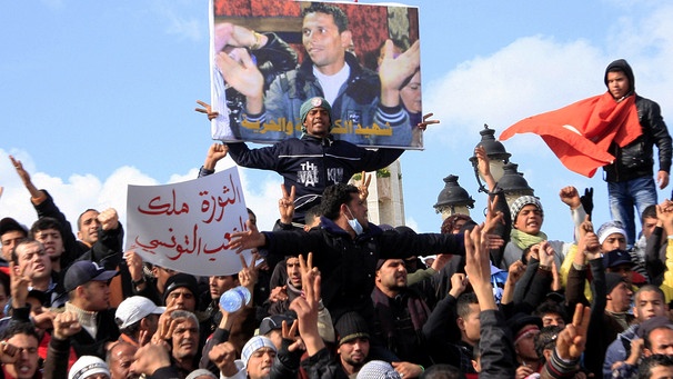 Wütende Demonstranten mit einem Bild "ihres" Märtyrers, des Gemüsehändlers Mohamed Bouazizi, im Januar 2011 in Tunis | Bild: picture alliance / ASSOCIATED PRESS | Salah Habibi