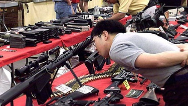 Besucher auf einer Waffenmesse in den USA begutachtet Sturmgewehre | Bild: picture-alliance / dpa | epa afp John Gurzinski