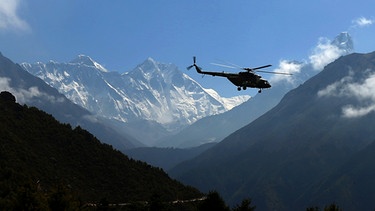 Namchebazar, Nepal: Ein Hubschrauber fliegt am Mount Everest vorbei. Aufnahme aus dem Sagarmatha National Park vom Mai 2020.
| Bild: picture alliance / ZUMAPRESS.com | Sunil Sharma