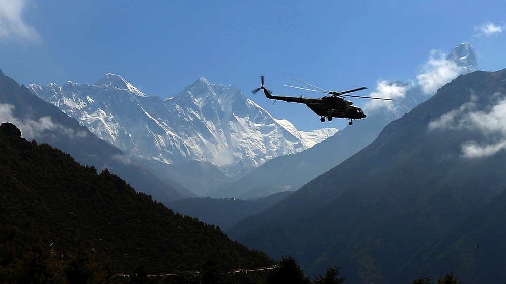 Namchebazar, Nepal: Ein Hubschrauber fliegt am Mount Everest vorbei. Aufnahme aus dem Sagarmatha National Park vom Mai 2020.
| Bild: picture alliance / ZUMAPRESS.com | Sunil Sharma
