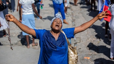 Eine Frau betet während eines religiösen Marsches in Port-au-Prince, Haiti. Hunderte von Haitianern machten so auf die Entführungswelle aufmerksam, der die Bewohner der Stadt zum Opfer gefallen sind.  | Bild: dpa-Bildfunk/Joseph Odelyn