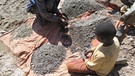 Kind in einer Kobaltmine sitzt auf dem Boden und arbeitet. | Bild: Thomas Coombes/amnesty international/dpa
