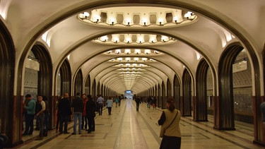 Moskau: Einige Menschen gehen bzw. stehen in einem langen Tunnel mit unzähligen Torbögen | Bild: BR/Christine Hamel