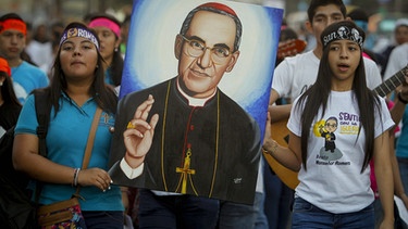 Erinnerung an Erzbischof Oscar Romero in El Salvador - Eine Prozession junger Menschen zieht mit dem Bild des als Märtyrer verehrten Erzbischofs Romero durch die Straßen von San Salvador | Bild: picture-alliance/dpa/ EPA/Oscar Rivera