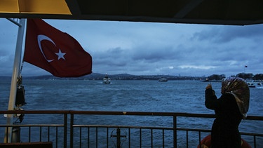 Eine Frau fotografiert bei der Überquerung des Bosporus auf dem Schiff | Bild: picture-alliance/dpa