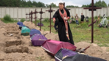 Ein Priester betet in Butscha während einer Zeremonie für nicht identifizierte Zivilisten, die während der russischen Besatzung in Butscha von den russischen Truppen ermordet wurden | Bild: dpa-Bildfunk/Efrem Lukatsky