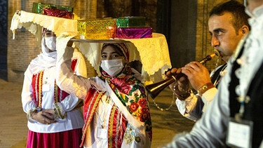 Iranerinnen und Iraner in lokaler Tracht feiern in Teheran das bevorstehende iranische Neujahrsfest (Nouruz), das am 20.03.2021 stattfand. Das Fest markiert den Frühlings- und Jahresbeginn im iranischen Kalender.  | Bild: dpa-Bildfunk/Ahmad Halabisaz