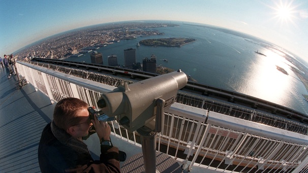 Auf der Aussichtsplattform des World Trade Centers in New York steht am 30.10.1998 einer der Besucher und sieht durch ein Aussichtsfernrohr "in Richtung Europa" auf den Atlantik hinaus. | Bild: picture-alliance/dpa